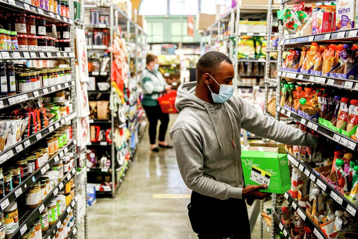 Employee Drexel Dorsey, 26, stocks the shelves at the Alameda Natural Grocery in Alameda, Calif. on Feb. 16, 2022.