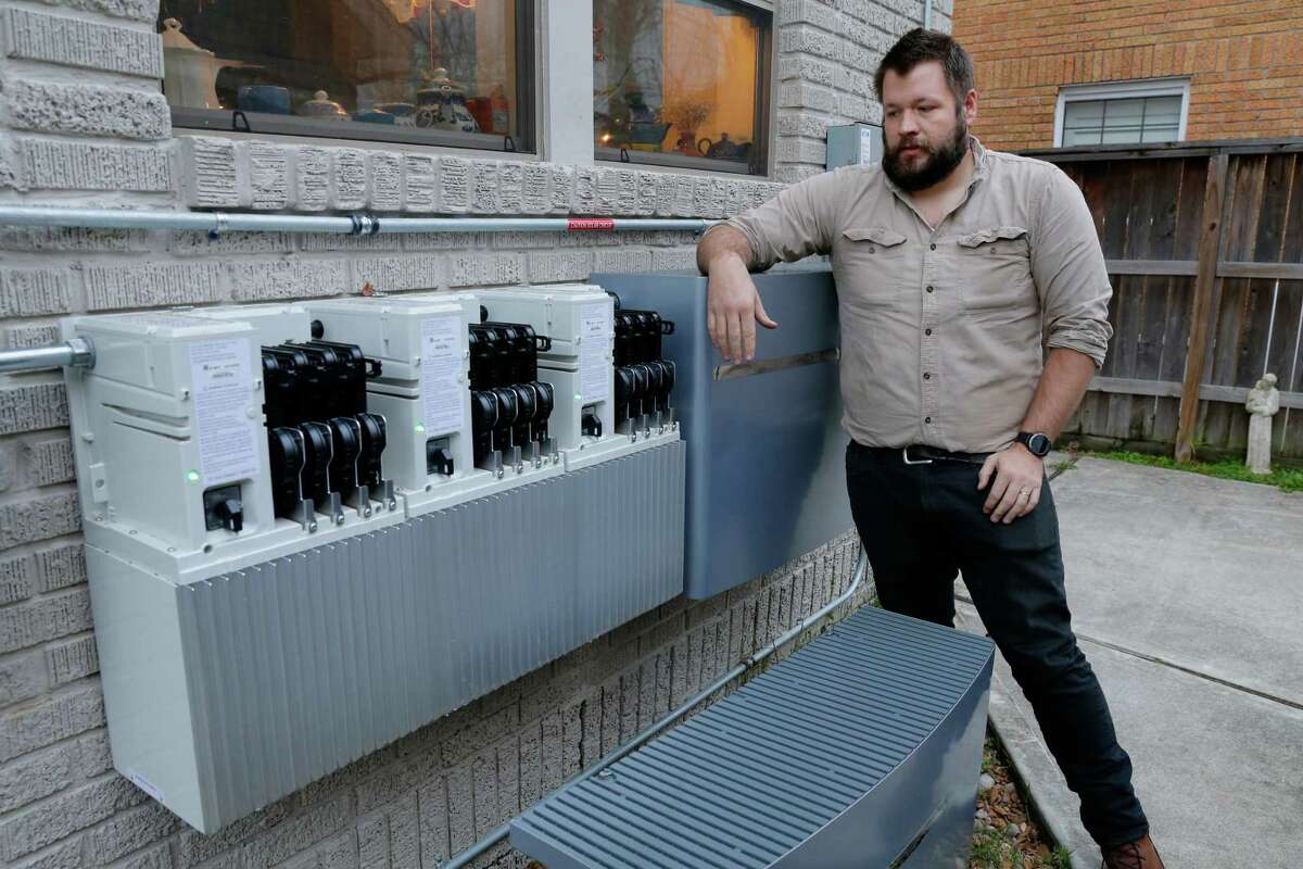 Sam Bryan talks about the battery panels in the back yard of the new solar panel power system he installed on the roof his two story 1930’s home Tuesday, Feb. 1, 2022 in Houston, TX.