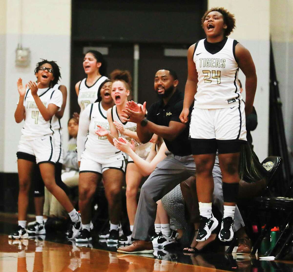 Conroe’s Ra’Niyah Castille (24) reacts after a basket beside teammates during the second quarter of a area high school basketball playoff game, Thursday, Feb. 17, 2022, in Spring.