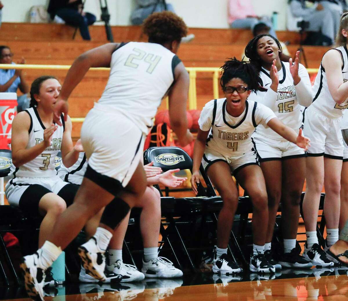 Conroe’s Alana Harris (4) gives Ra’Niyah Lewis (24) a high-five after making a shot during the third quarter of a area high school basketball playoff game, Thursday, Feb. 17, 2022, in Spring.