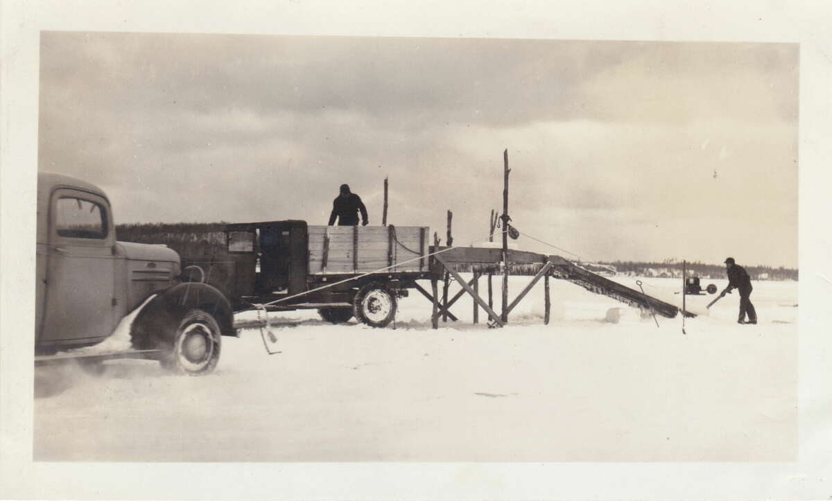 Loading ice blocks on Crystal Lake by rope and pulley. Rope was tied to truck bumper, the truck backs up and slides the block up the ramp.