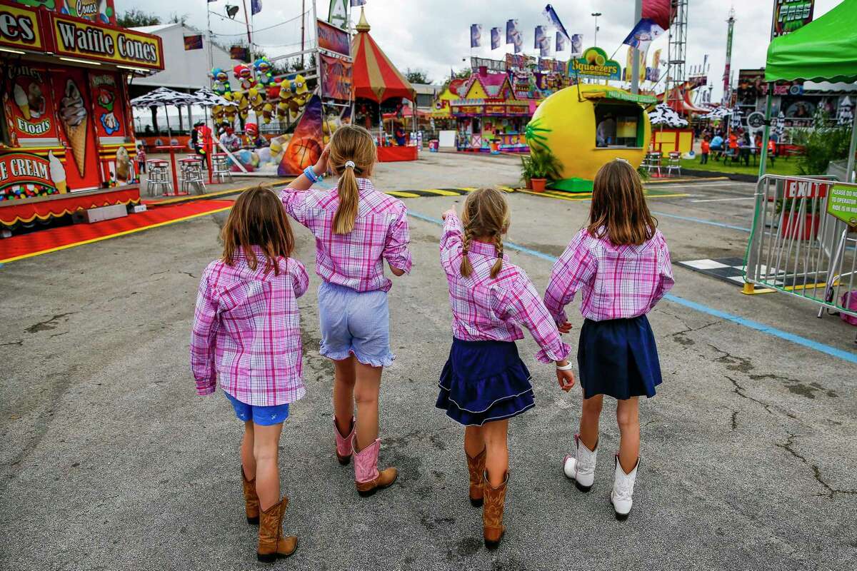 Archer Williams, Julia Hunter Williams, Claire Kapinos and Holt Williams, look for the next carnival game at the Houston Livestock Show and Rodeo.