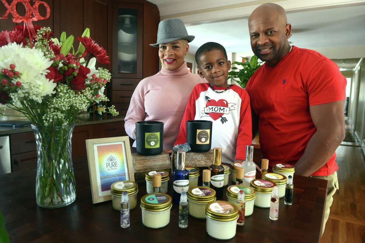 Shasha Cadet poses with her husband, JR, and their son Major at home in Trumbull on Feb. 14, 2022. Pure By Shasha is Cadet’s line of health and beauty products created and marketed from the family’s Trumbull home.