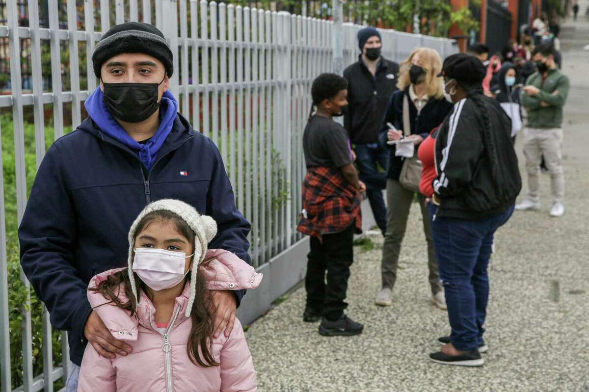 Dennis Sanchez waits in line for a COVID-19 test with his daughter Melanie, 6, while at Bayview Opera House in San Francisco.