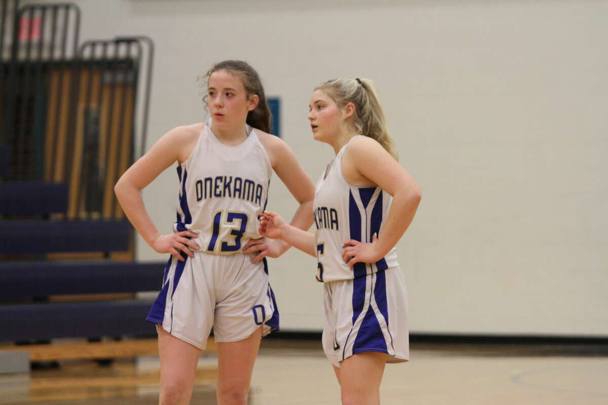 Hailey Hart (left) and Heather Zielinski (right) talk about the next play while Buckley shoots free throws. 