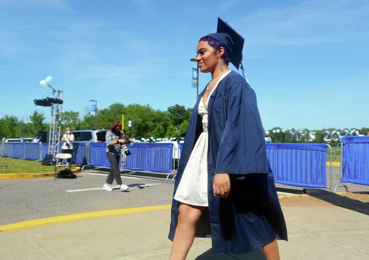 A member of the Middletown High School class of 2020 walks across the parking lot to accept her diploma. The ceremony was held outdoors due to the pandemic.