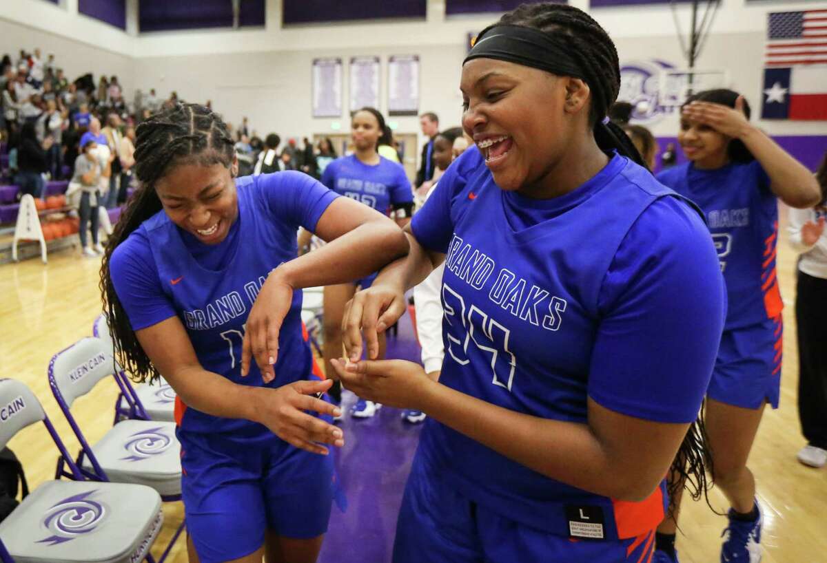 Grand Oaks High School Grizzlies Madison McCollister (14) and Tamia Alexander (34) celebrate after they beat the Cypress Ranch High School Lady Mustangs in a Region II-6A area girl’s basketball playoff game Friday, Feb. 18, 2022, at Klein Cain High School in Houston.