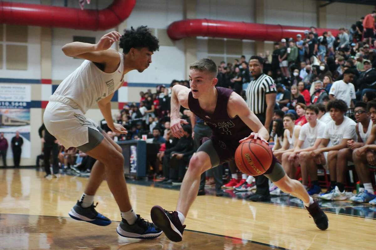 Pearland’s Clay Page (3) drives to the basket past Dawson’s Tyree Davis (2) Wednesday at Dawson High School. Both teams begin the Class 6A playoffs next week.