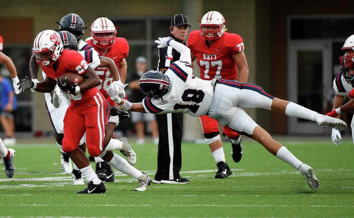 Katy running back Seth Davis, left, breaks the tackle of Tompkins defensive back Evan Tymon (18) en route to a touchdown during the first half of a high school football game, Friday, Oct. 1, 2021, in Katy. Davis and teammate Jacob Egg (58) were among the Tigers’ all-state selections from the Texas Sports Writers Association.