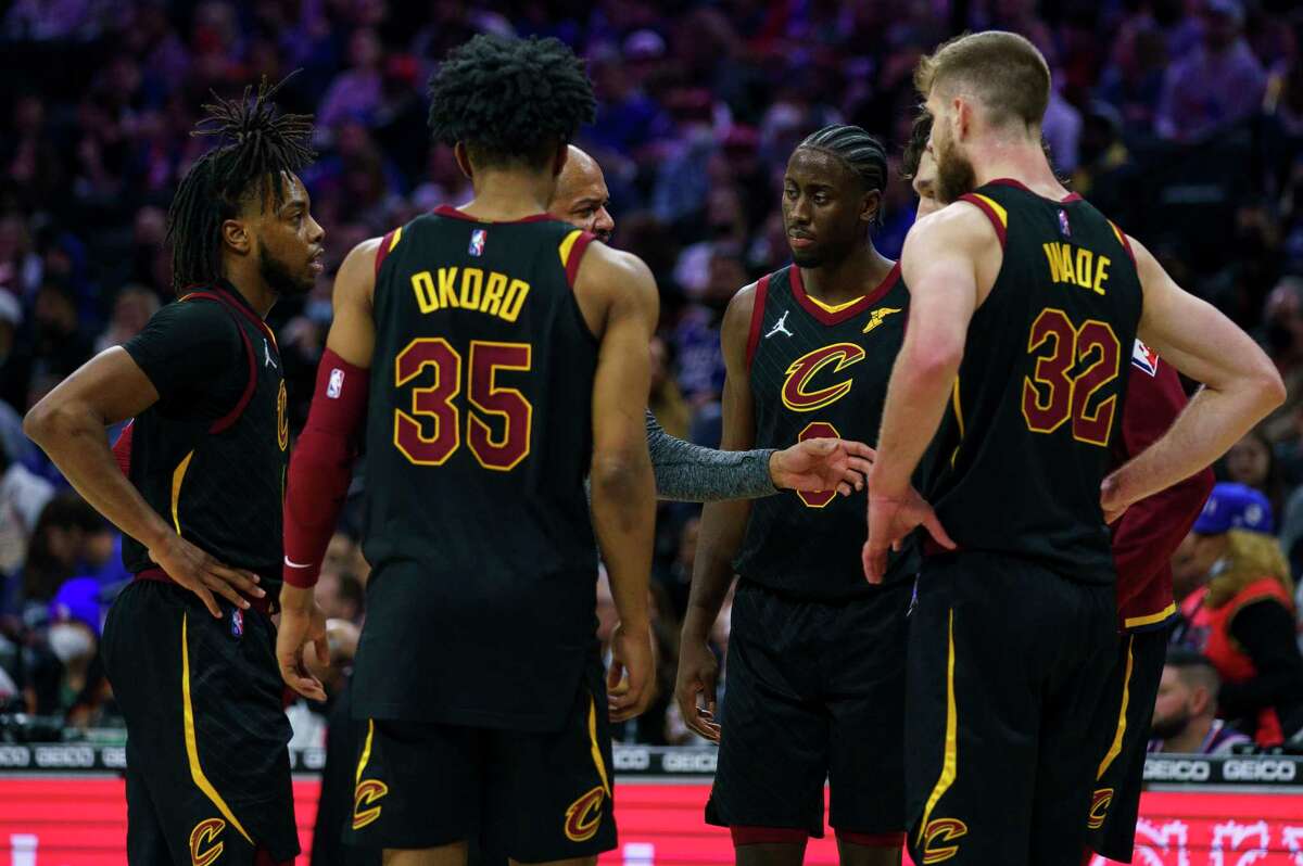 Cleveland Cavaliers head coach J.B. Bickerstaff, center, talks things over with his team during the second half of an NBA basketball game against the Philadelphia 76ers, Saturday, Feb. 12, 2022, in Philadelphia. The 76ers won 103-93. (AP Photo/Chris Szagola)