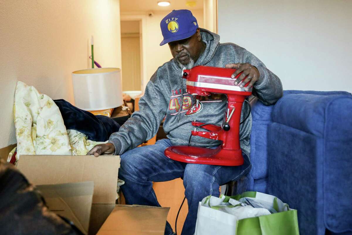 Leroy Beasley unpacks his wife’s mixer at the Frederick Douglas Haynes Garden Apartments in San Francisco. The family is facing a $500 rent increase each year over the next five years.