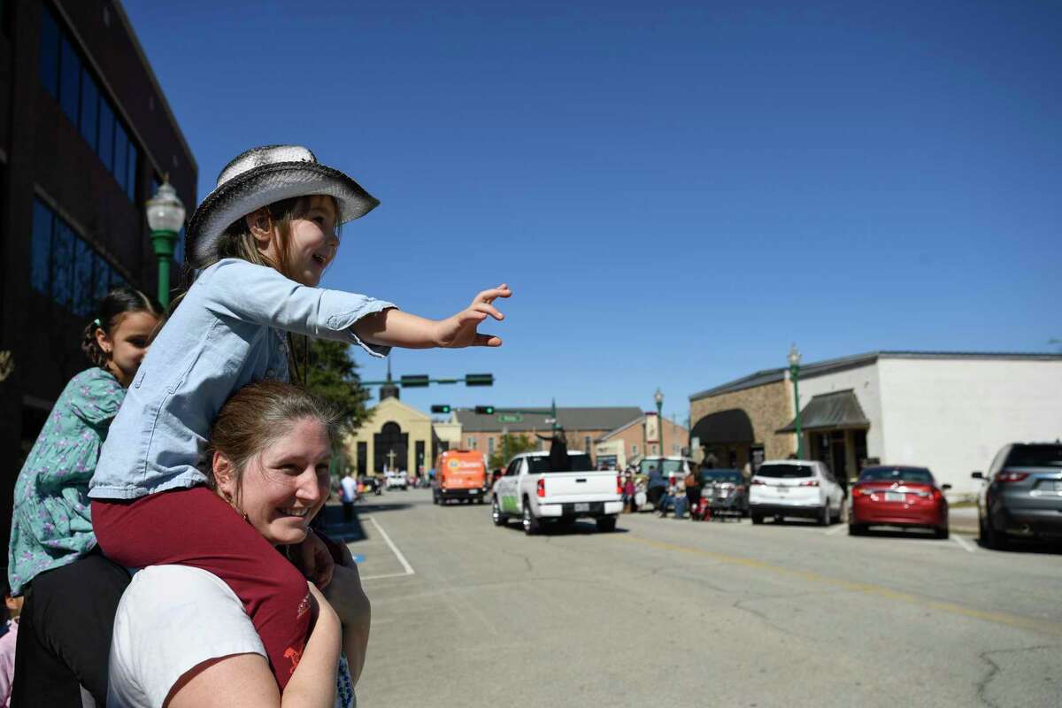 Madelyn Keys watches the parade on the shoulders of her mom, Erica during the 57th Annual Go Texan Parade Saturday, Feb. 19, 2022, in Conroe, Texas.