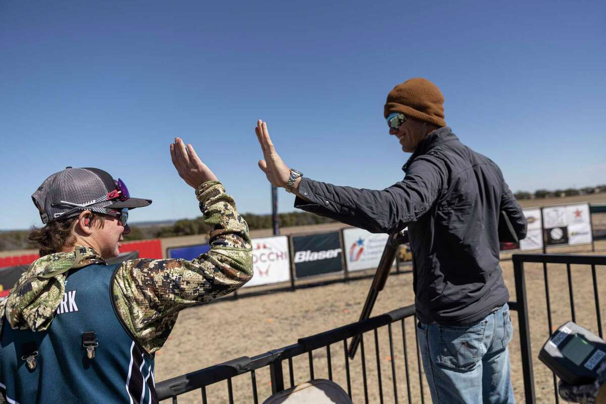 Ty Rorak, 16, of Carrizo Springs high-fives professional shooter Cory Kruse after an impromptu sporting clays shoot-out at the San Antonio Stock Show & Rodeo Junior Shoot-Out. Rorak got tips from Kruse and two other professional shooters.