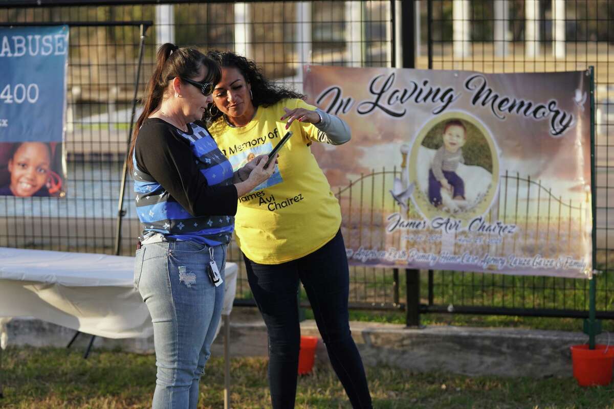 Candace McGill and Marisol Benavidez look at a smartphone photo of Benavidez’s great-nephew, James Chairez, during a vigil Saturday for victims of child abuse. James was 1 year old when he disappeared in January 2021. His remains later were discovered beneath the West Side mobile home he shared with his mother. She has been charged with evidence tampering in the case. The circumstances of the boy’s death remain a mystery.