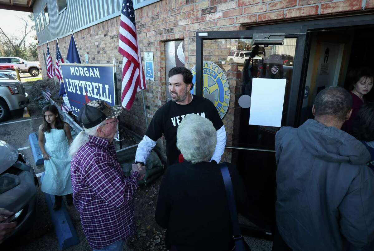 Morgan Luttrell, a congressional candidate, greets supporters before the Texas First Rally on Saturday, Feb. 19, 2022, at Honor Cafe in Conroe. He removed his hat each time he greeted a woman in the line.