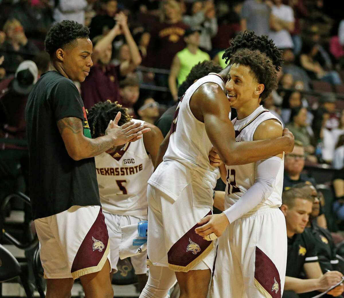 Texas State guard Mason Harrell (12) is hugged as he comes to the bench late in the second half. Texas State defeated Little Rock 68-50 at Strahan Arena in San Marcos on Saturday, Feb. 19, 2022