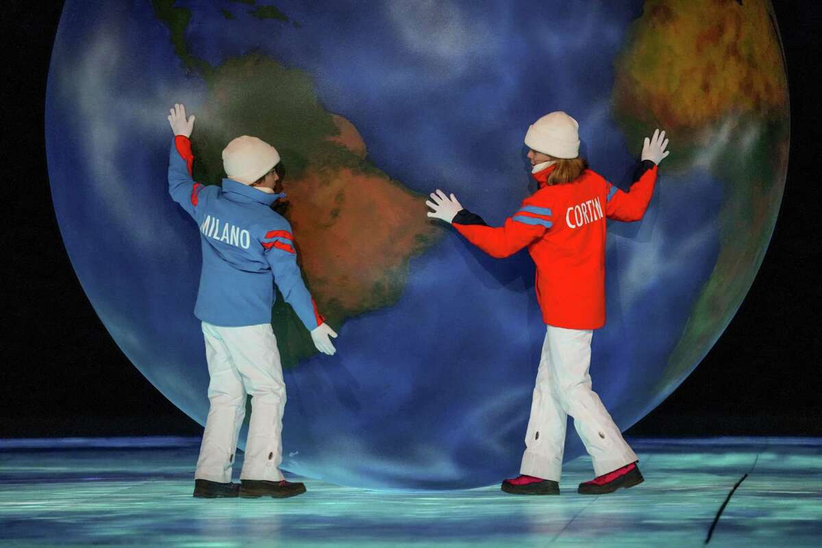 Two children representing the 2026 Milano Cortina Winter Olympics roll a globe on cracking ice during the closing ceremony of the 2022 Beijing Winter Olympics in Beijing, on Sunday, Feb. 20, 2022. (Gabriela Bhaskar/The New York Times)