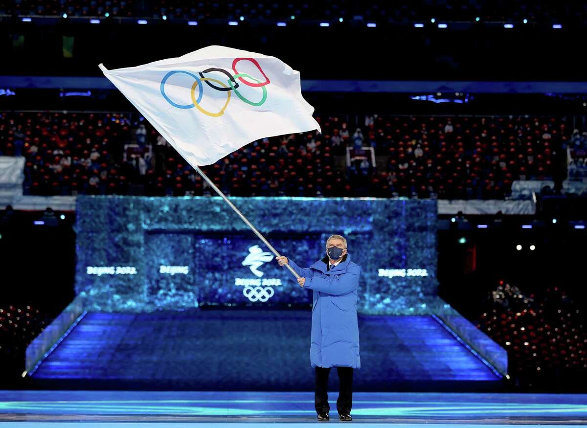BEIJING, CHINA - FEBRUARY 20: Thomas Bach, IOC President waves the flag of the IOC during the Beijing 2022 Winter Olympics Closing Ceremony on Day 16 of the Beijing 2022 Winter Olympics at Beijing National Stadium on February 20, 2022 in Beijing, China. (Photo by Maja Hitij/Getty Images)