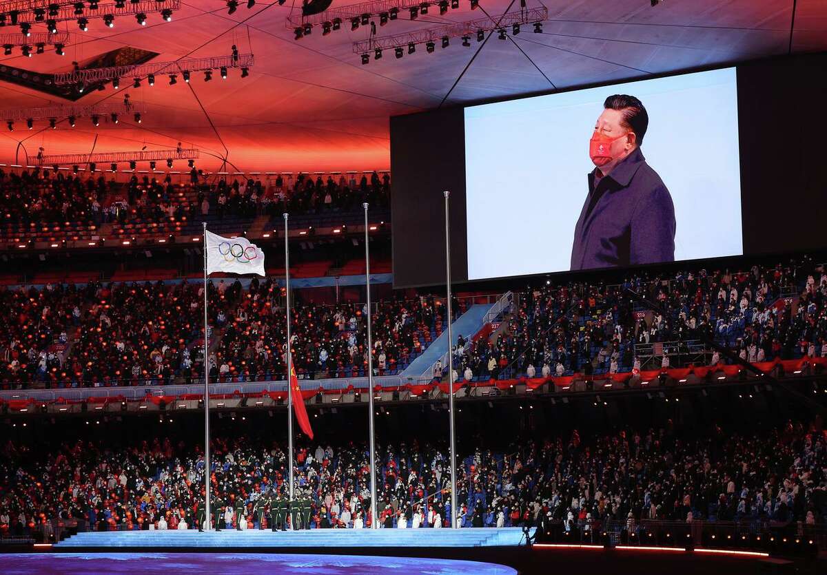 Xi Jinping, president of China, is seen on a big screen as the Olympic flag flies prior to the Beijing 2022 Winter Olympics Closing Ceremony at Beijing National Stadium.