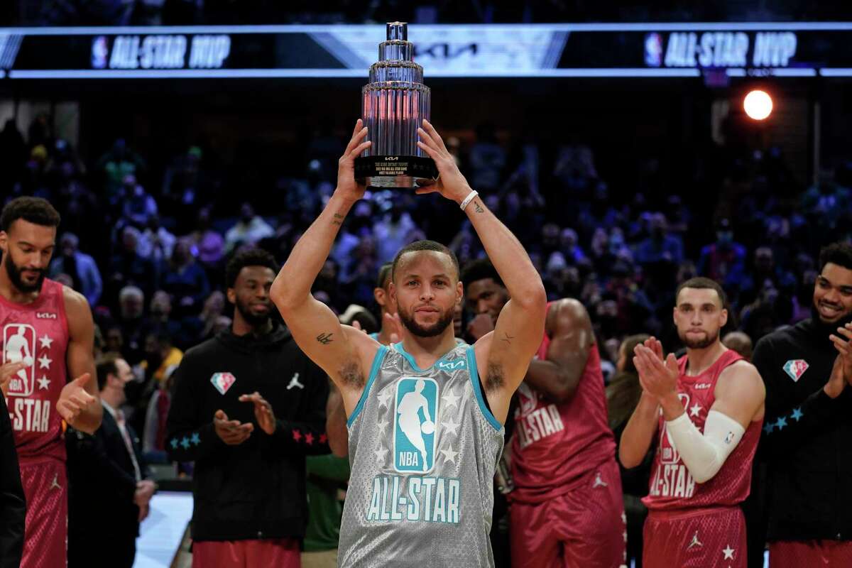 Golden State Warriors' Stephen Curry holds up the Kobe Bryant Trophy after being named the MVP of the NBA All-Star basketball game, Sunday, Feb. 20, 2022, in Cleveland. (AP Photo/Charles Krupa)