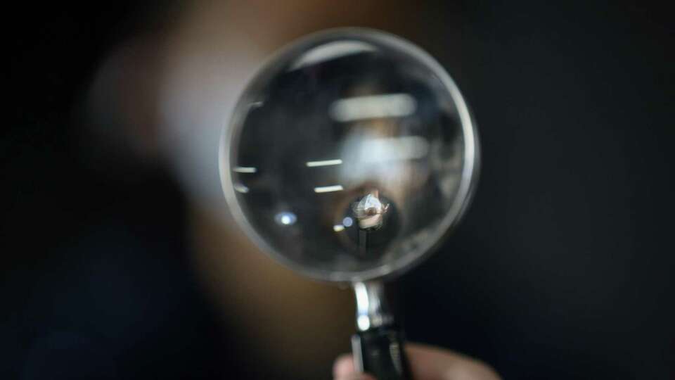 Aishani Gargapati, a Rice University student, is seen in a magnifying glass as she takes part in a discussion Saturday, Feb. 19, 2022, at the Houston Climate Justice Museum and Cultural Center in Houston.