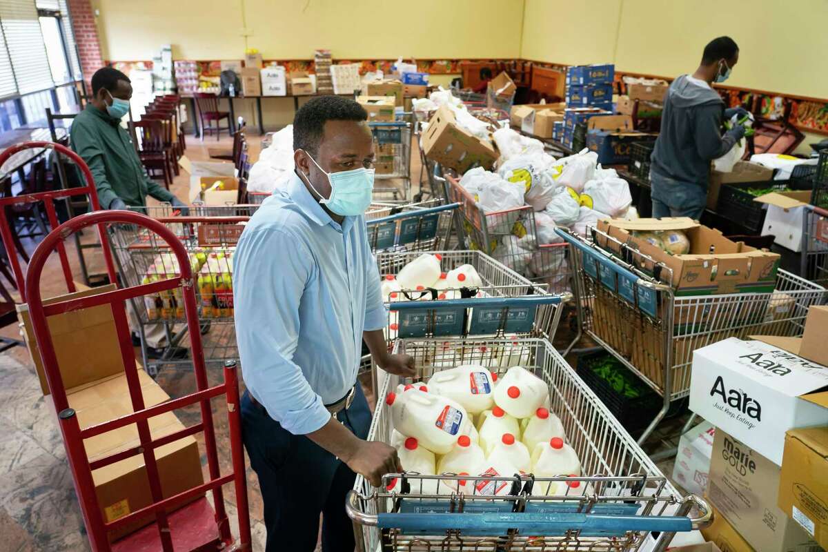 Makki Makki, the refugee housing program manager with The Alliance, stands amid the food his team packs and distributes daily to resettled families in Houston in a partnership with the World Food Mart on Beechnut Street, Thursday, Feb. 17, 2022, in Houston.