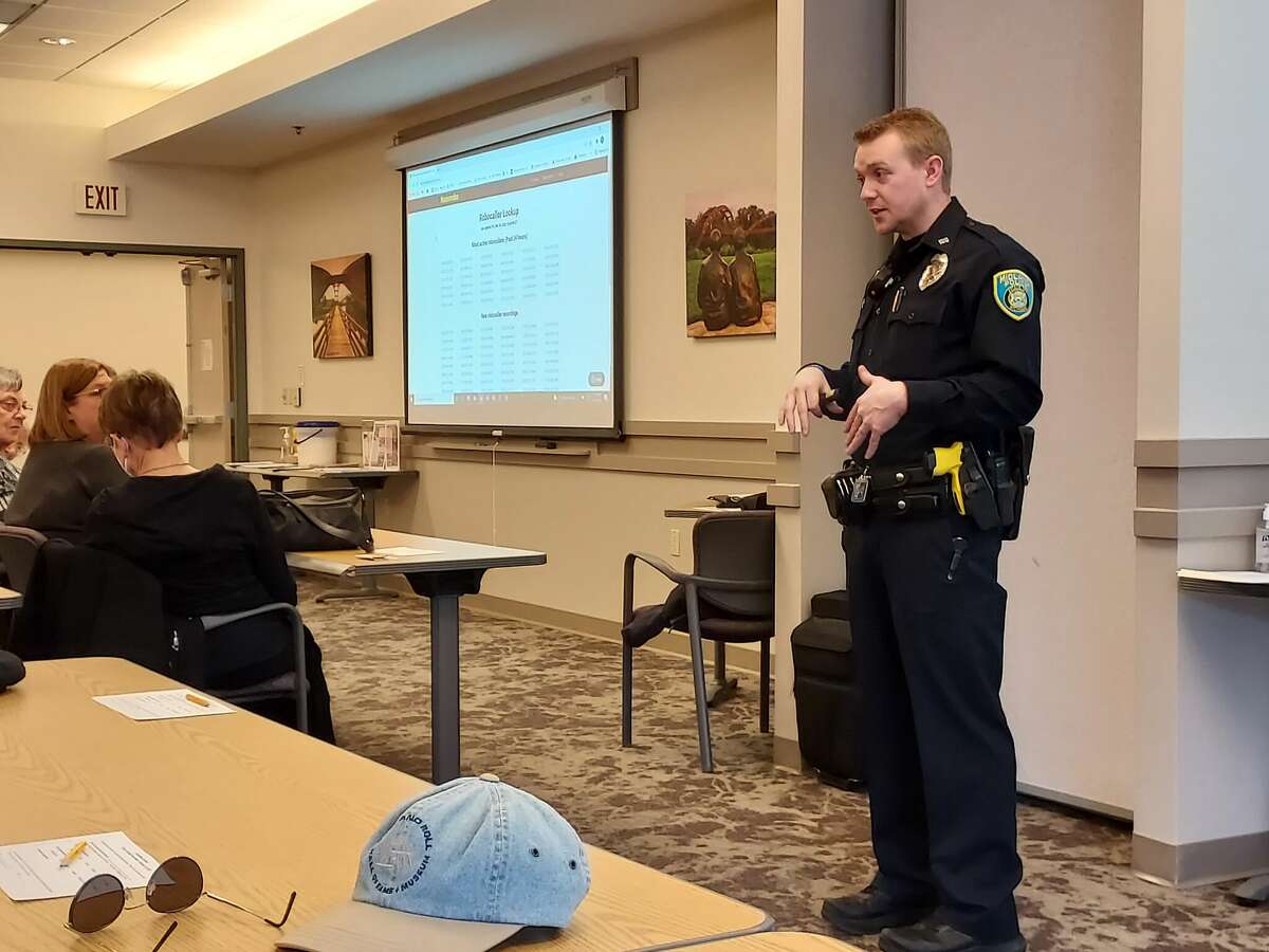 Midland Police Department Officer Brennon Warren talks to seniors recently at Trailside Senior Center about how to avoid scams.