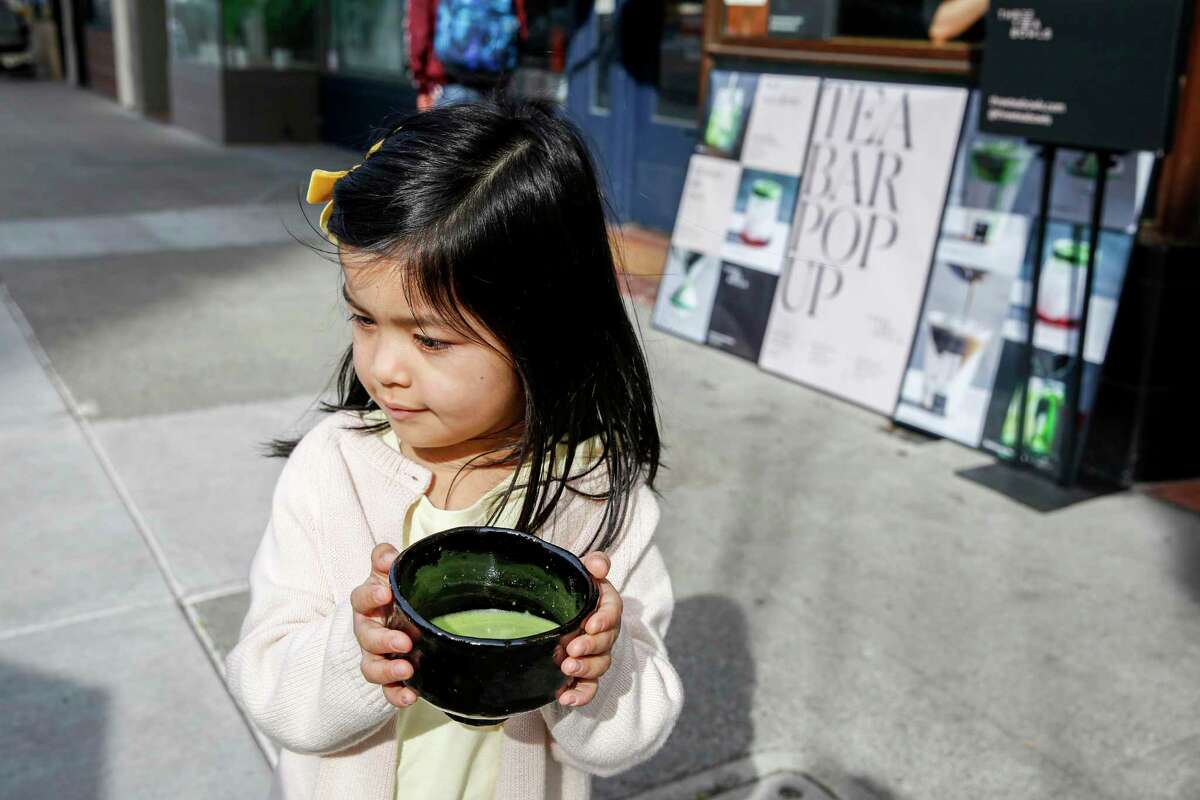 Evelyn Chang, 4, holds a bowl of ceremonial matcha outside of the Three Tea Bowls pop-up at Gadani in Berkeley.