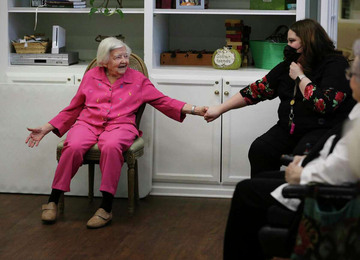 World War II veteran Maureen Davis receives a handshake from Ruby Ballin, the activity director, after Davis led a calisthenics class at her assistant living facility in Jourdanton last week. Davis celebrated her 105th birthday Tuesday.