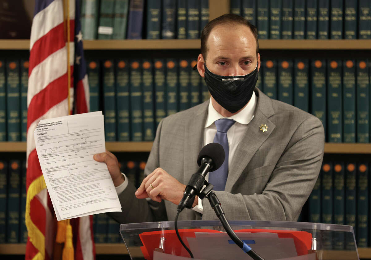 San Francisco District Attorney Chesa Boudin holds up a copy of the California state medical examination form for sexual assault victims as he speaks during a press conference at his office on Feb. 15, 2022 in San Francisco.