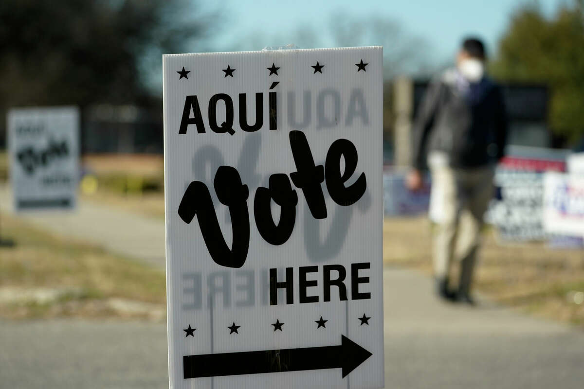 A man passes an early voting poll site, Monday, Feb. 14, 2022, in San Antonio. 