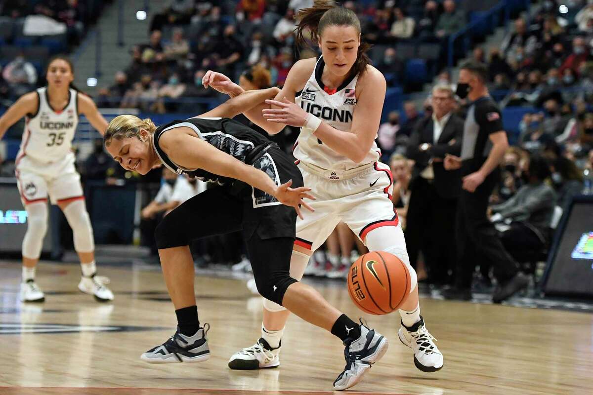 Connecticut's Nika Mühl steals the ball from Georgetown's Kaylin West, left, in the first half of an NCAA college basketball game, Sunday, Feb. 20, 2022, in Hartford, Conn. (AP Photo/Jessica Hill)