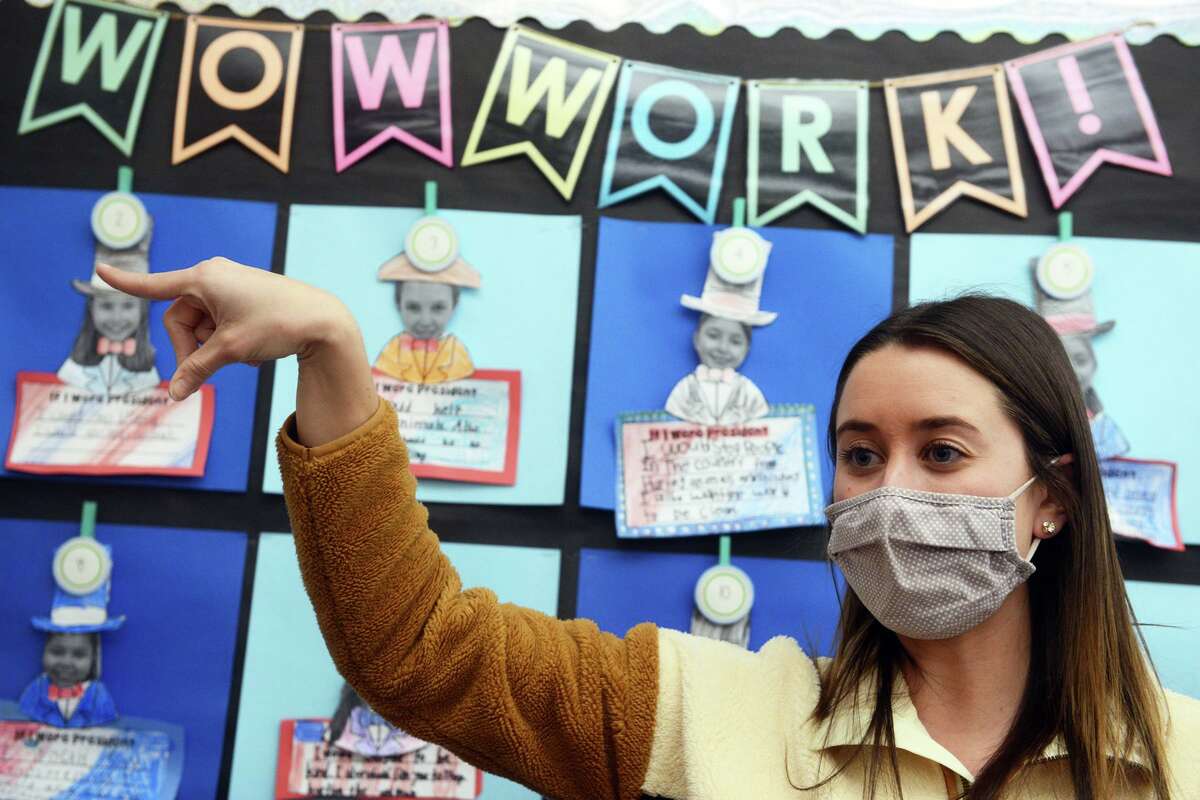 Second grade teacher Hannah Haydu uses sign language as she works with her students at Samuel Staple Elementary School, in Easton, Conn. Feb. 22, 2022.