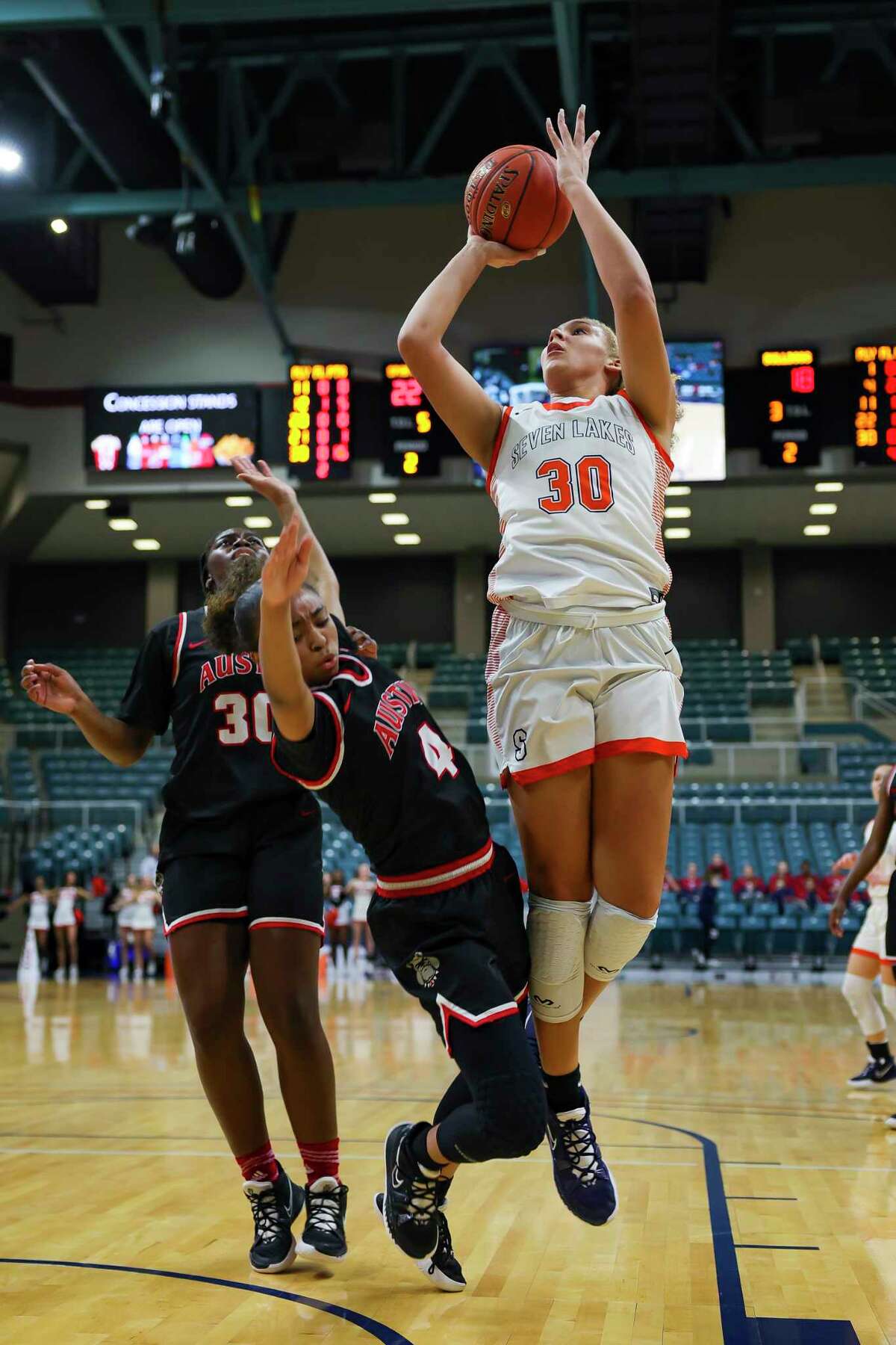 Seven Lakes forward Justice Carlton (30) shoots over Austin guard Aminah Dixon (4) during the first half of a Region III-6A quarterfinals game between the Seven Lakes Spartans and Austin Bulldogs, Tuesday, Feb. 22, 2022, at the Merrell Center in Katy.