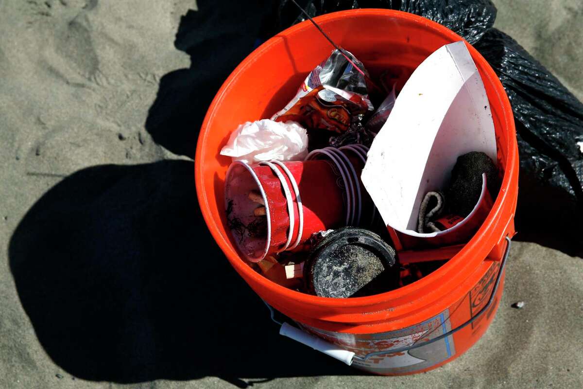A plastic bin full of trash picked up from Ocean Beach in San Francisco during a coastal cleanup in 2016. The state Ocean Protection Council is expected to adopt a plan Wednesday to address the microplastic particles that flake off tires, clothing, plastic bags and countless other items before making their way to the water.