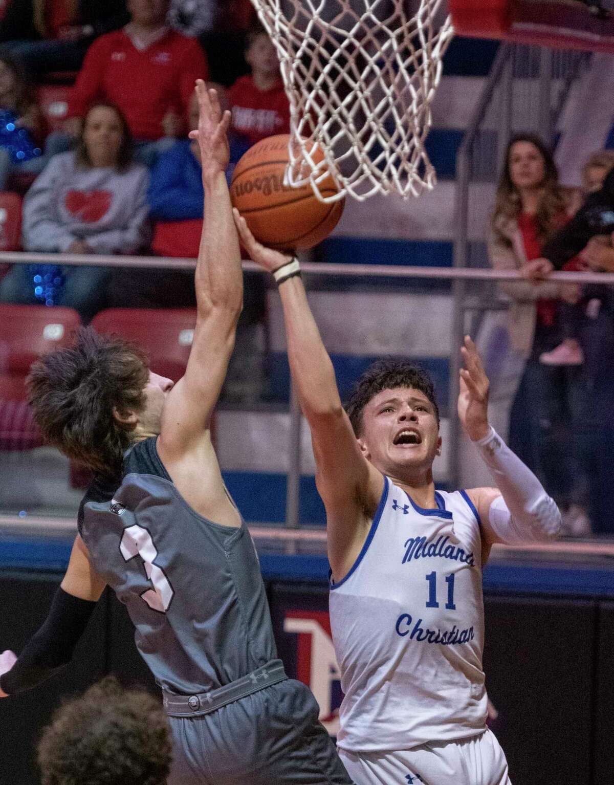 Midland Christian's Deshaun Ortiz goes up for a shot as Dallas Bishop's Grayson Bell defends 02/22/2022 during the TAPPS 6A area playoff at the McGraw Event Center. Tim Fischer/Reporter-Telegram