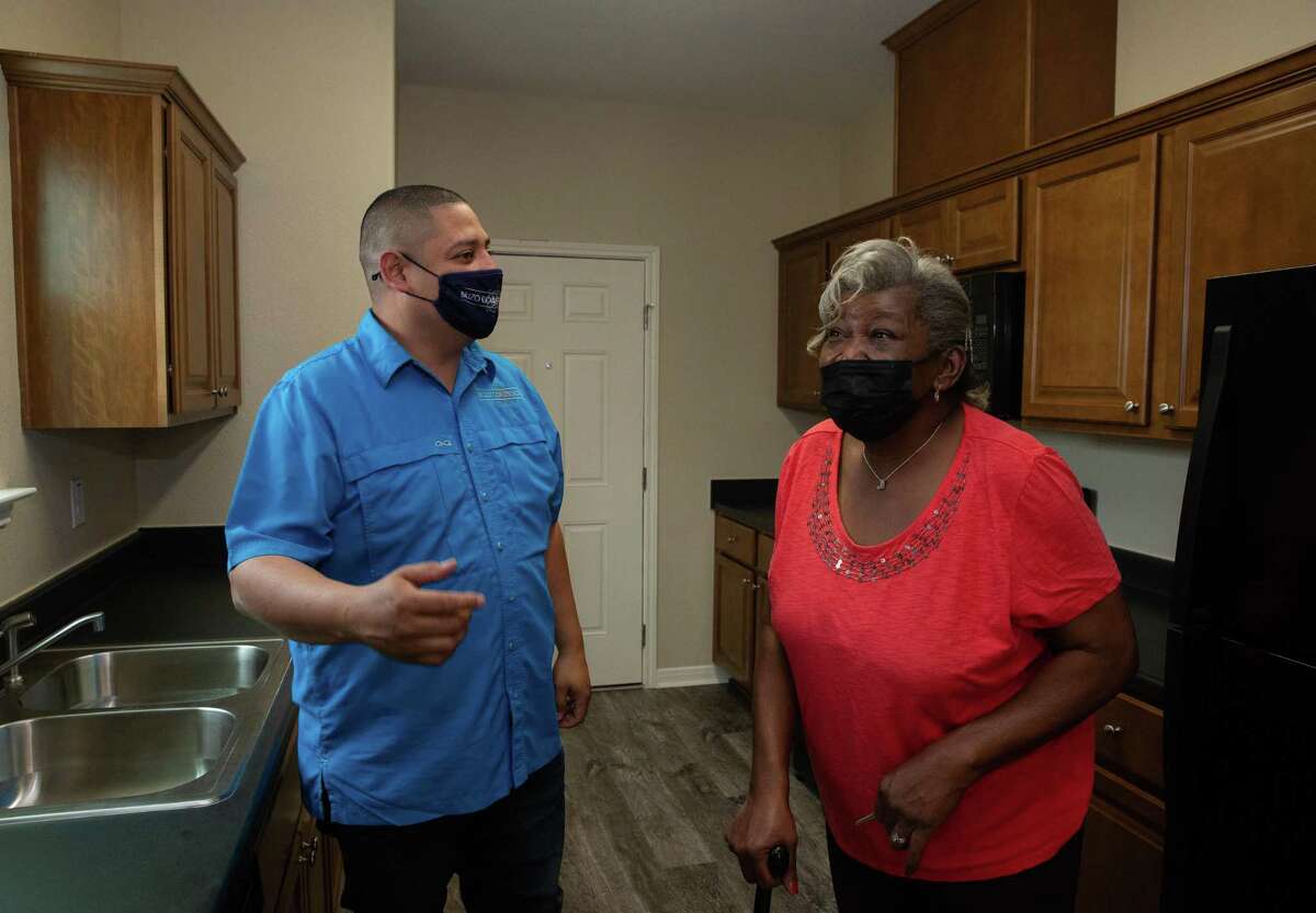 Juanita Hall is excited to see her new kitchen after her house has been rebuilt — nearly five years after her home was flooded during Hurricane Harvey — while Brizo Construction Construction Manager Ernesto Moreira is showing her around Tuesday, Feb. 22, 2022, in Houston.