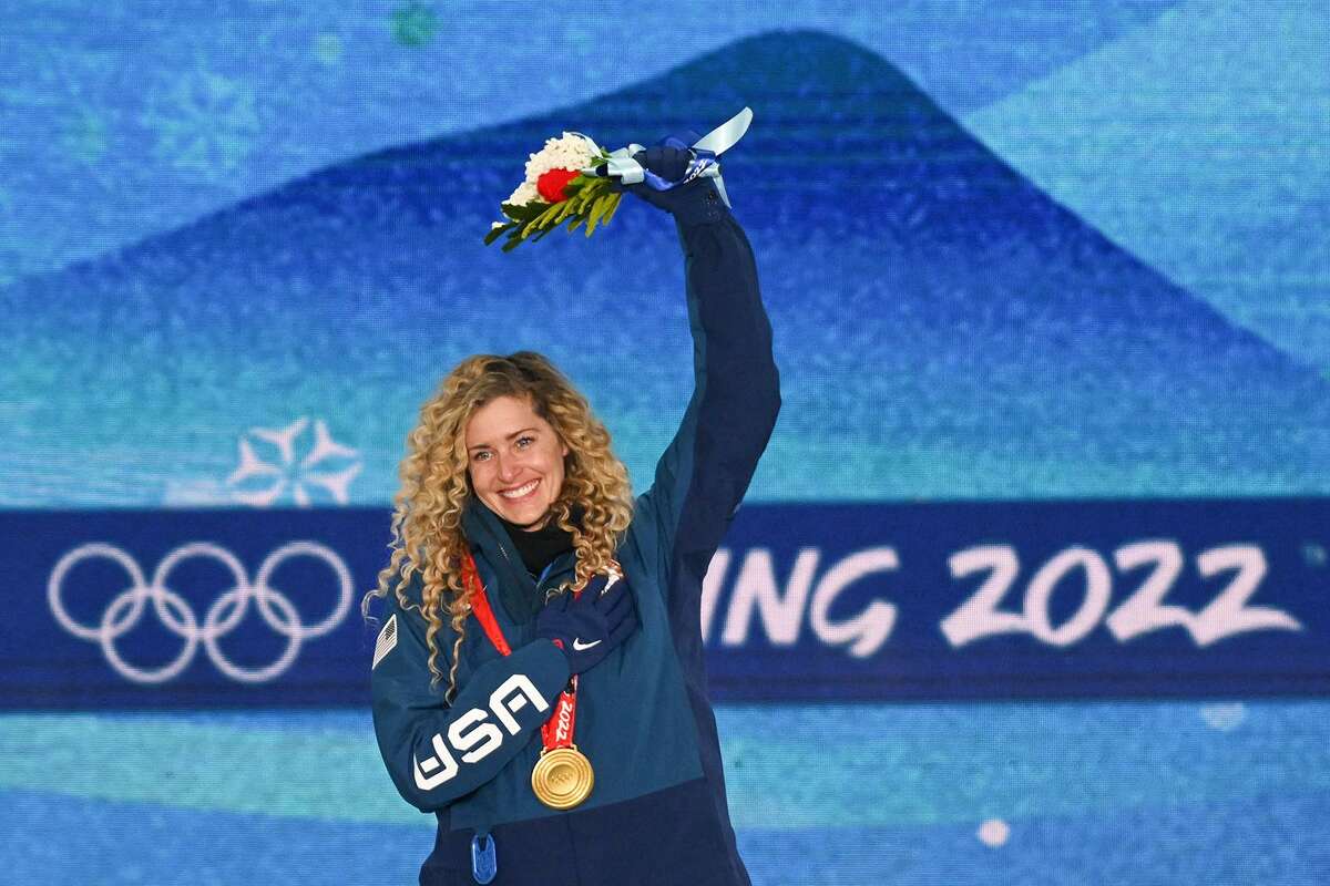 Gold medalist Lindsey Jacobellis celebrates on the podium during the women’s snowboard cross victory ceremony at the Beijing 2022 Winter Olympic Games at the Zhangjiakou Medals Plaza on Feb. 9, 2022. She won her second gold medal with her partner, Nick Baumgartner, in snowboard’s mixed cross on Saturday in Beijing.