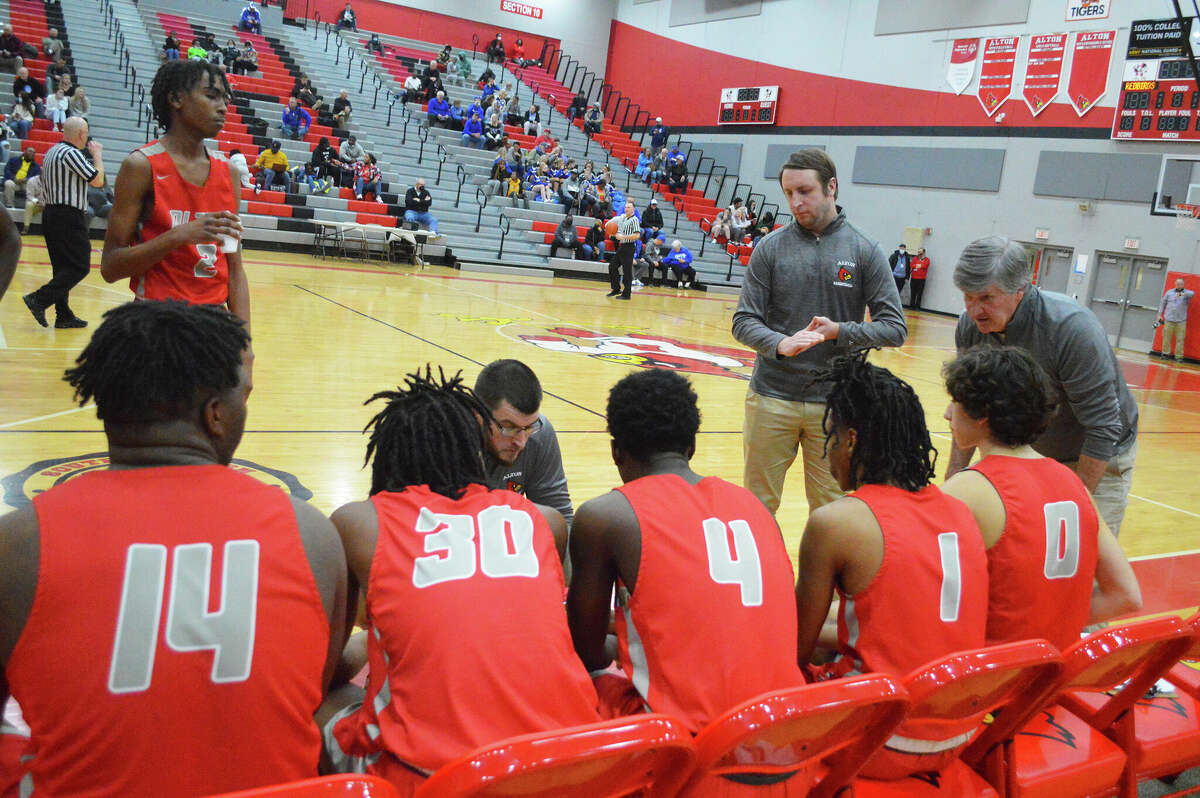 Alton coach Eric McCrary, center, has resigned after one season as the Alton Redbirds boys basketball coach. Above, McCrary talks to his players during during Tuesday's game against O'Fallon in the first round of the Class 4A Alton Regional.