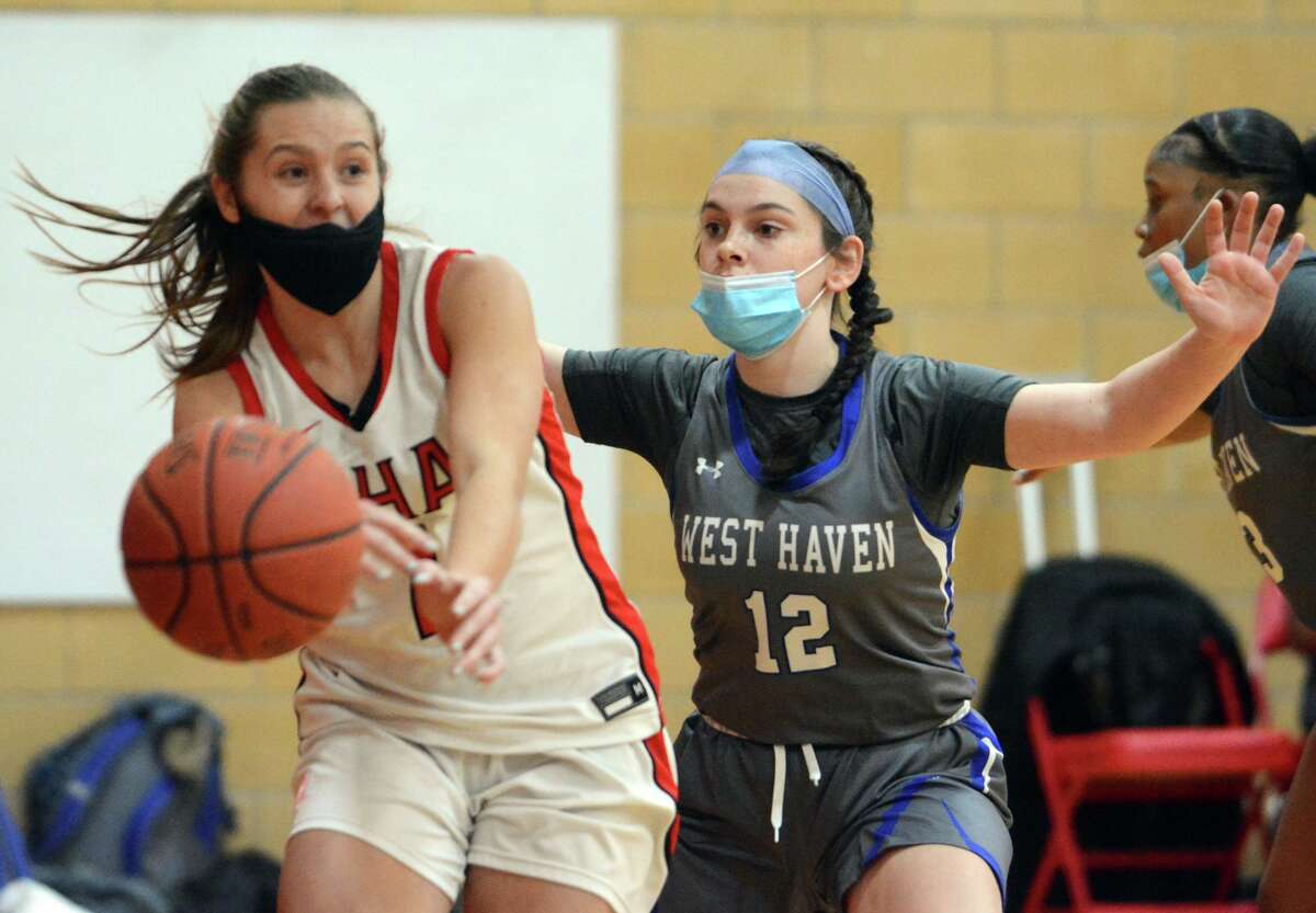 Emma Kirck of Sacred Heart Academy passes the ball to a teammate while Isabella Fiorillo of West Haven defends.