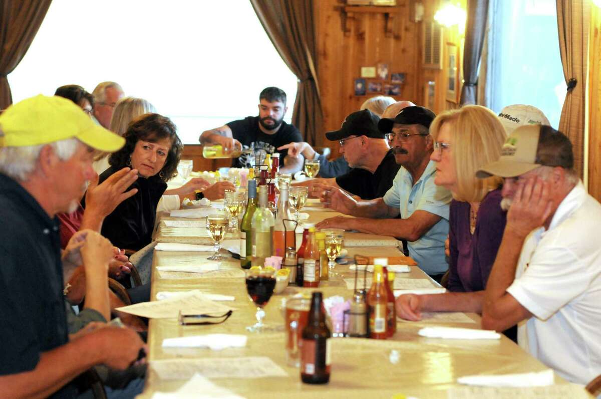 A large table of customers sit down for a meal at Acadiana Café.