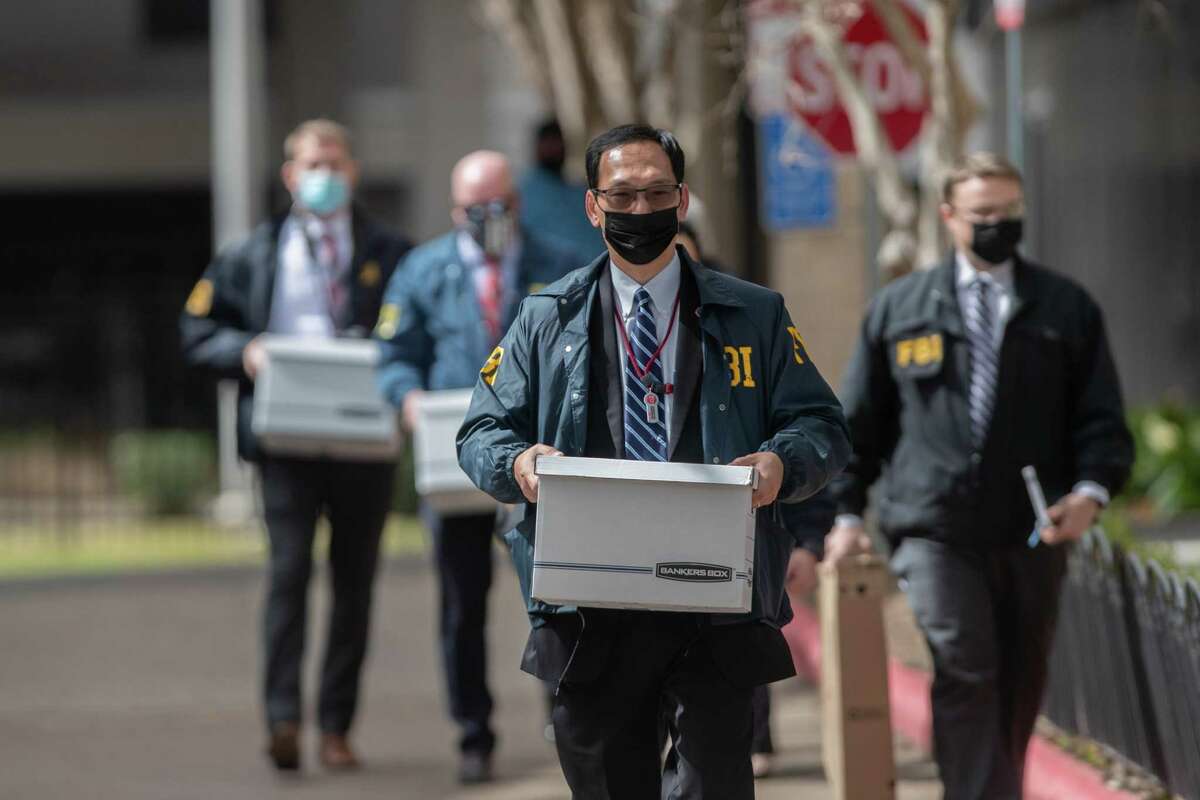 FBI personnel exit the Houston Health Department carrying boxes, Wednesday, Feb. 16, 2022, in Houston.