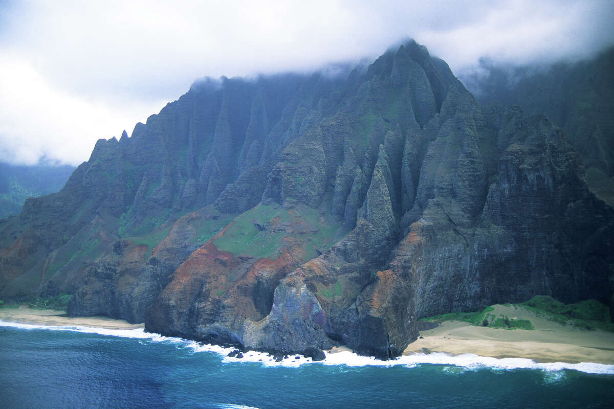 View of the Napali Coast from a helicopter on the island of Kauai, Hawaii. The 11-mile Kalalau Trail winds itself through its many valleys and ends at Kalalau Beach, pictured on the left.