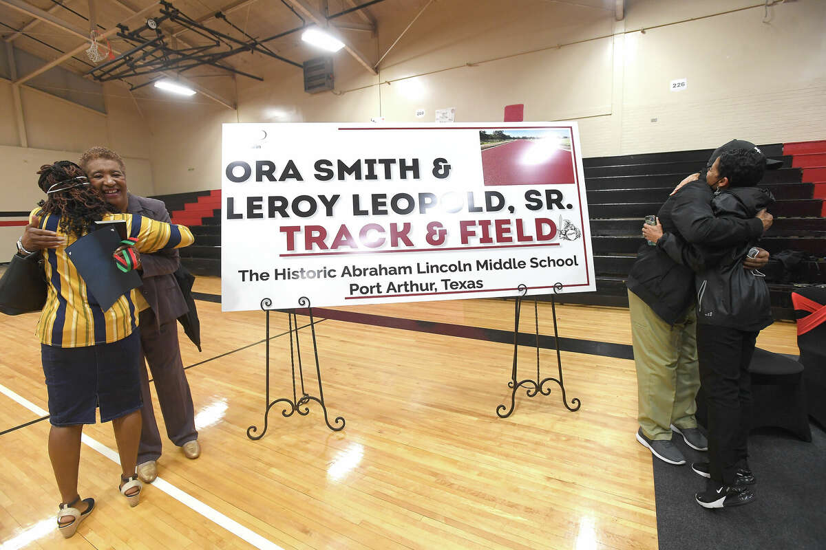 Ora Smith and Leroy Leopold, Sr., get hugs of congratulations during the ceremony renaming the Abraham Lincoln Middle School track to the Ora Smith and Leroy Leopold, Sr.,Track & Field. The coaches helped create a strong program and paved the way for the success of many Port Arthur athletes. Photo made Wednesday, February 23, 2022 Kim Brent/The Enterprise