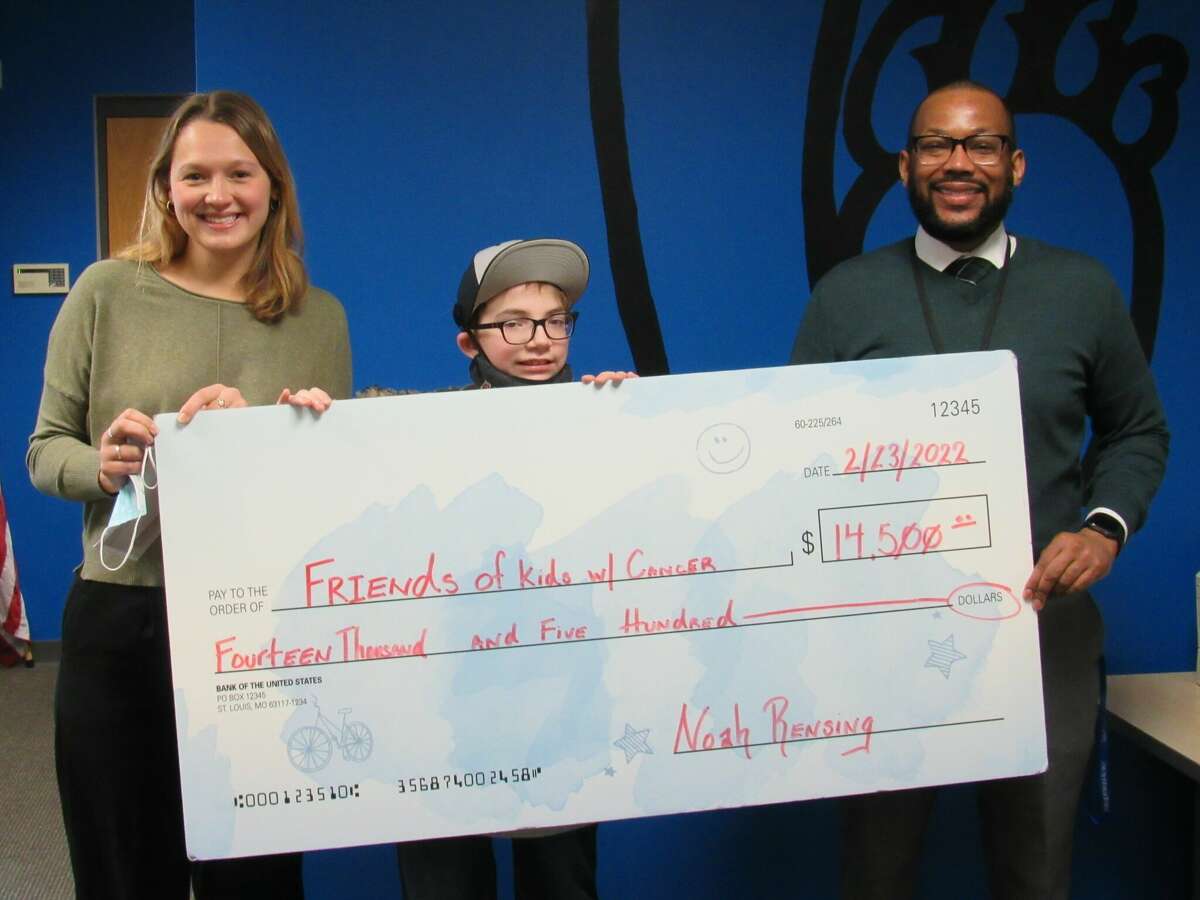 On Wednesday, Liberty Middle School seventh-grader Noah Rensing, middle, along with Principal Allen Duncan, right, presented a $14,500 check to Eva Schuller, Development Coordinator of Friends with Kids with Cancer. The presentation marked the culmination of Rensing's fundraiser for the organization, during which over 800 "I Stand with Heroes" T-shirts designed by Rensing were sold. "It's really wonderful to see a kid that has benefited from our services turn around and raise money for us," Schuller said. "We have a host of programming from tutoring to art therapy to all of the fun end-of-chemo parties, and so this will really go a long way in helping all of the kids that we serve." 