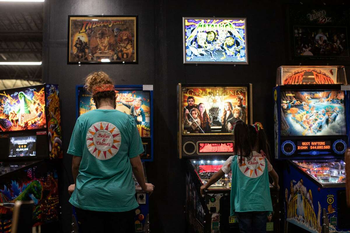 Elizabeth Hoff and her daughter Daisy, 6, play pinball before a Belles & Chimes San Antonio tournament begins at What's Brewing Coffee Roasters. The women’s pinball group has several mother-and-daughter members.