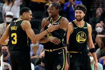 Klay Thompson (11) and Jordan Poole (3) react to Jonathan Kuminga's (00) dunk in the second half as the Golden State Warriors played the Dallas Mavericks at Chase Center in San Francisco, Calif., on Tuesday, January 25, 2022.