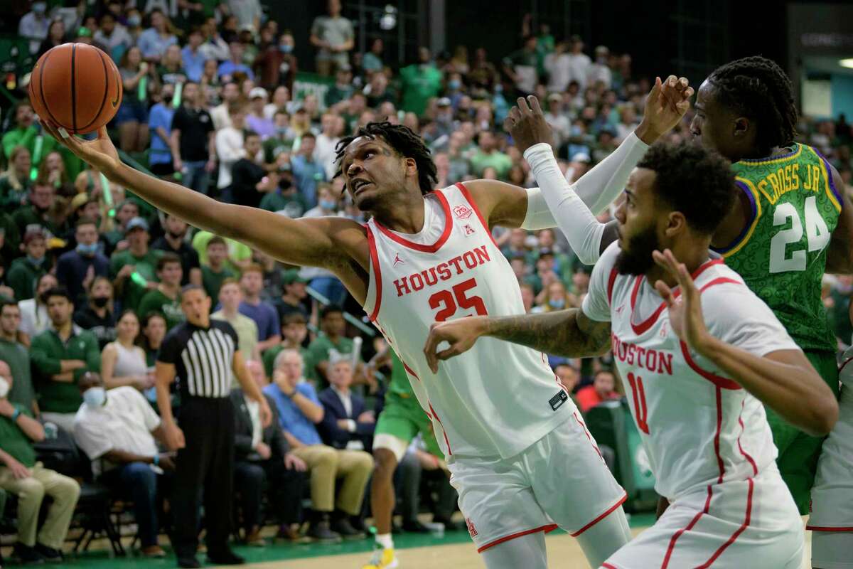 Houston center Josh Carlton (25) reaches for a rebound next to Tulane forward Kevin Cross (24), as Houston guard Kyler Edwards (11) watches during the first half of an NCAA college basketball game in New Orleans, Wednesday, Feb. 23, 2022. (AP Photo/Matthew Hinton)