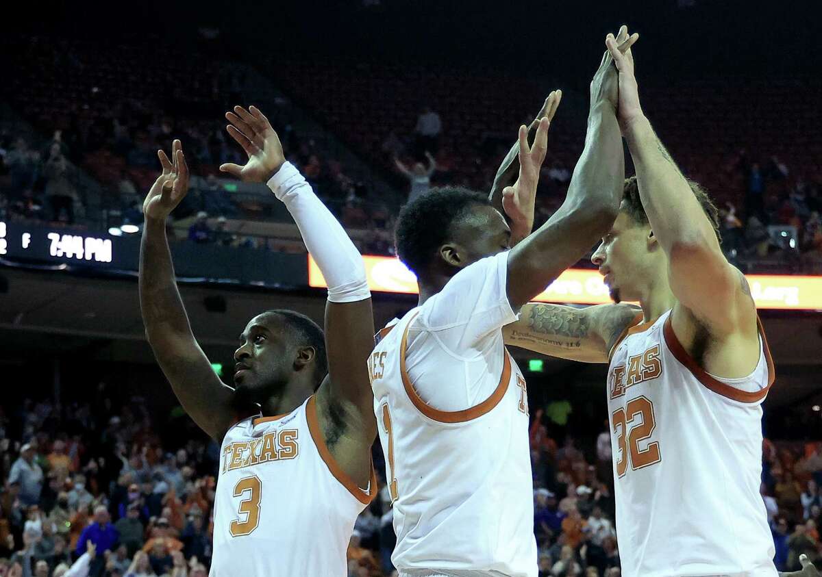 Courtney Ramey #3, Andrew Jones #1 and Christian Bishop #32 of the Texas Longhorns react as they defeat TCU 75-66 at the Frank Erwin Center on February 23, 2022 in Austin, Texas.