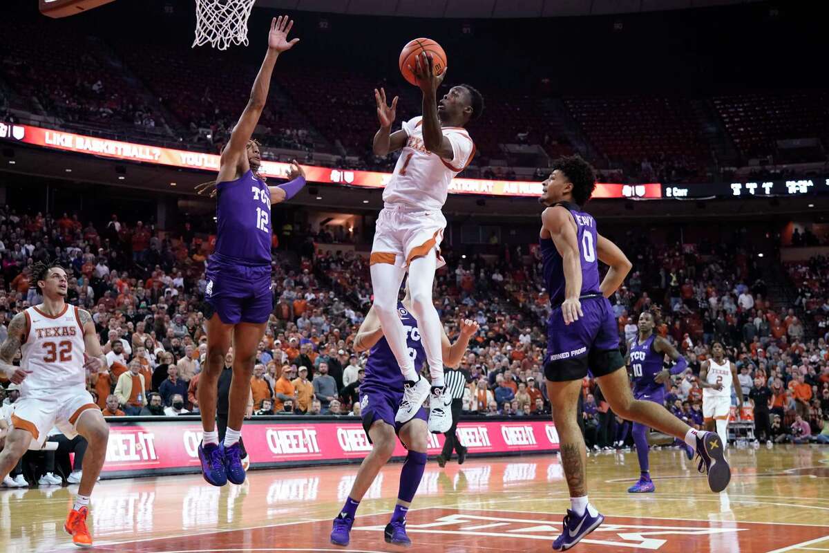 Texas guard Andrew Jones (1) drives past TCU guard Micah Peavy (0) and forward Xavier Cork (12) during the second half of an NCAA college basketball game in Austin, Texas, Wednesday, Feb. 23, 2022. (AP Photo/Chuck Burton)